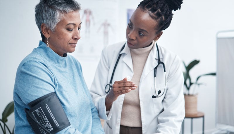 senior woman getting blood pressure taken in a medical room