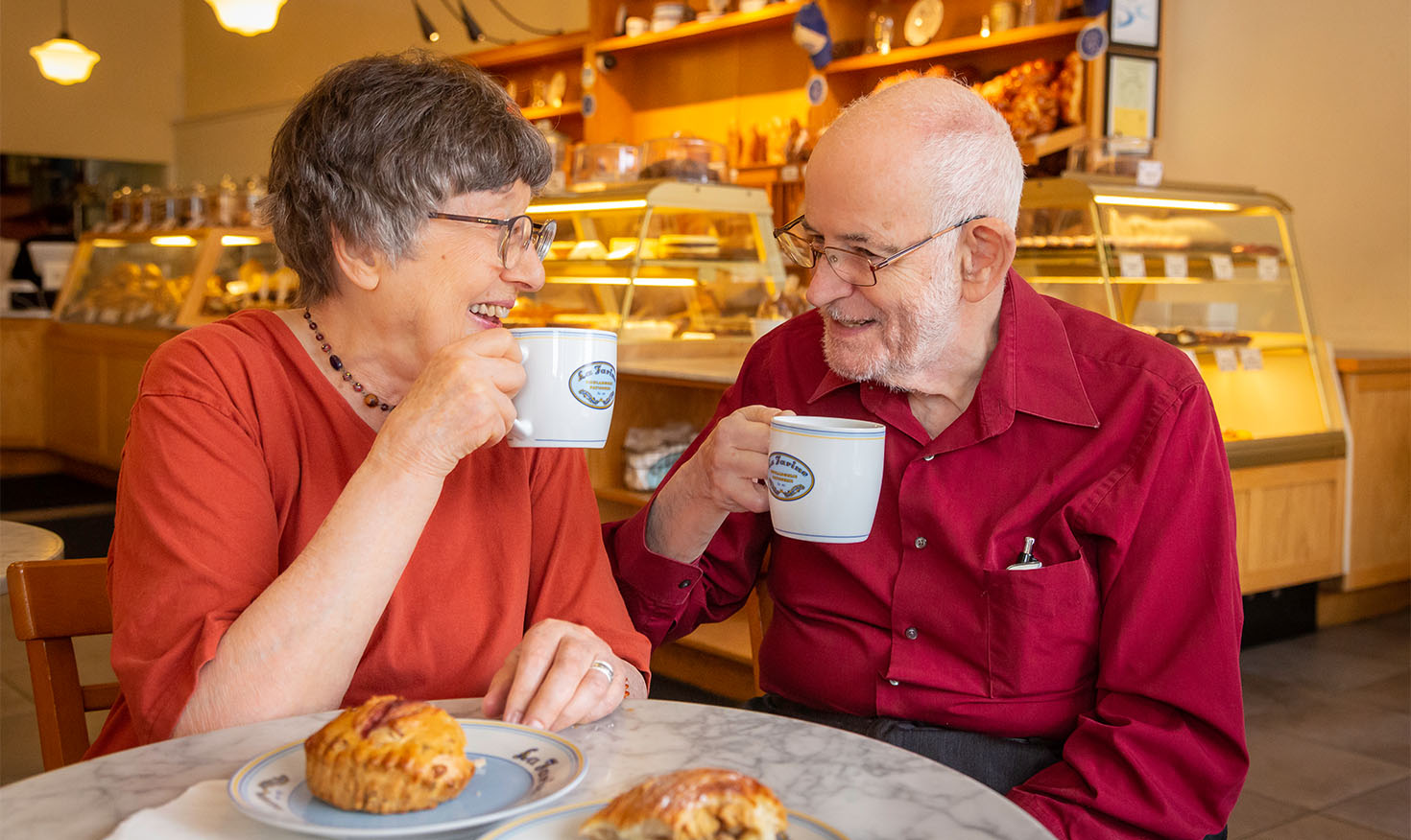 seniors enjoying coffee and pastries at cafe