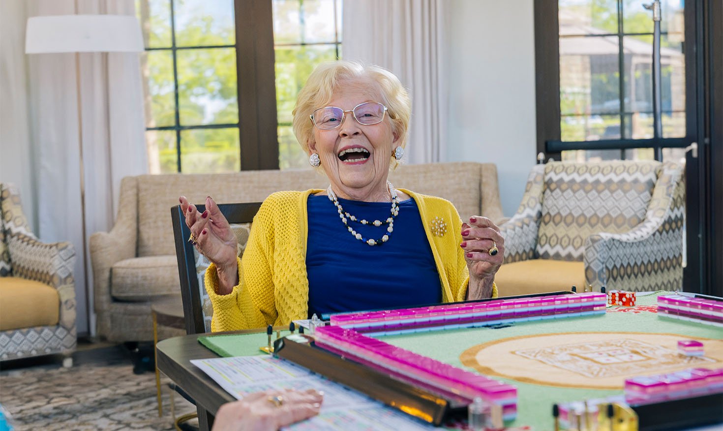 senior smiling while playing majong