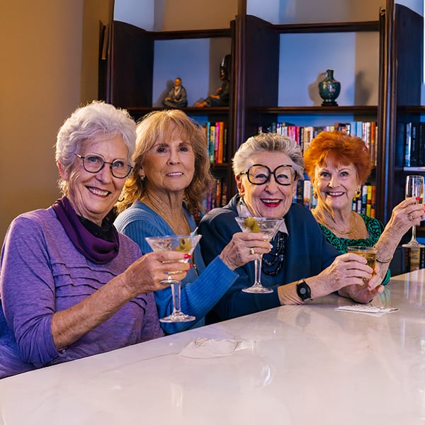 senior friends drinking martinis at the bar