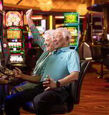 seniors sitting at slot machine at a casino