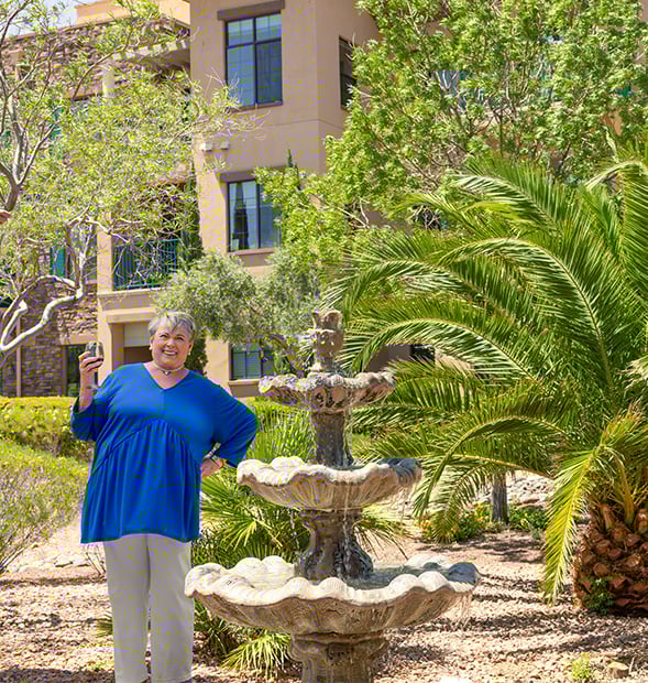 senior holding a glass of wine while walking outside