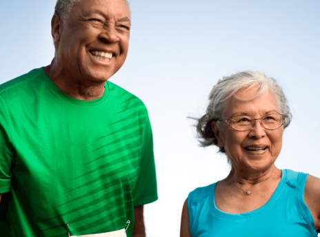 Smiling senior woman and man standing next to each other outside